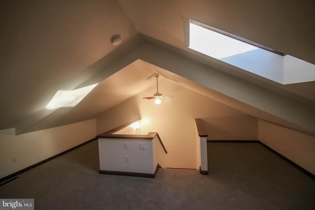 additional living space with dark carpet, vaulted ceiling, and ceiling fan