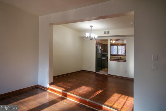 unfurnished room with dark hardwood / wood-style floors and a notable chandelier