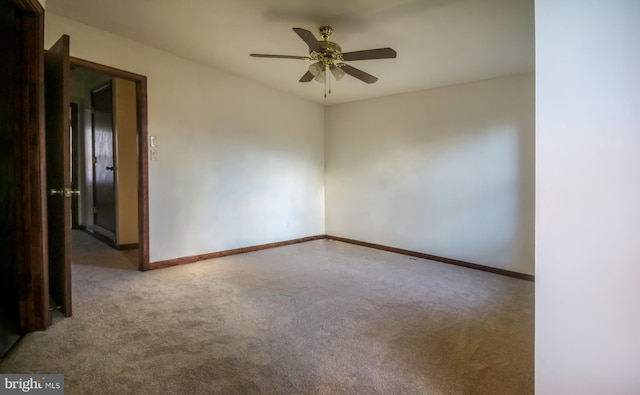 carpeted spare room featuring ceiling fan