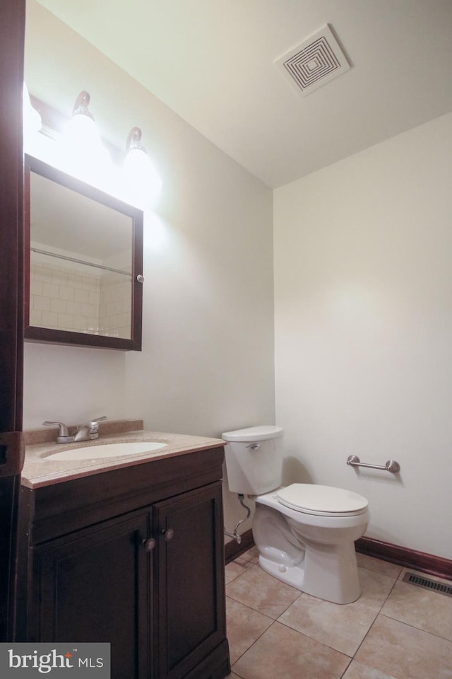 bathroom featuring toilet, vanity, and tile patterned floors