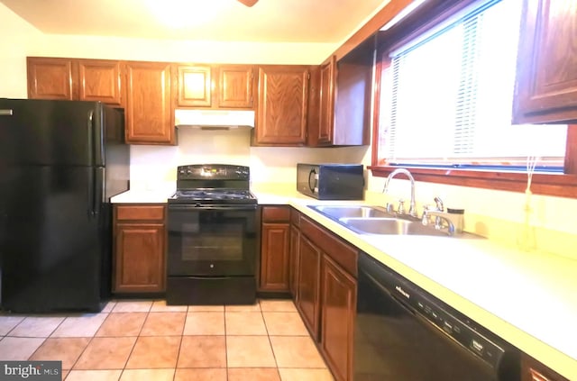 kitchen featuring black appliances, light tile patterned floors, and sink