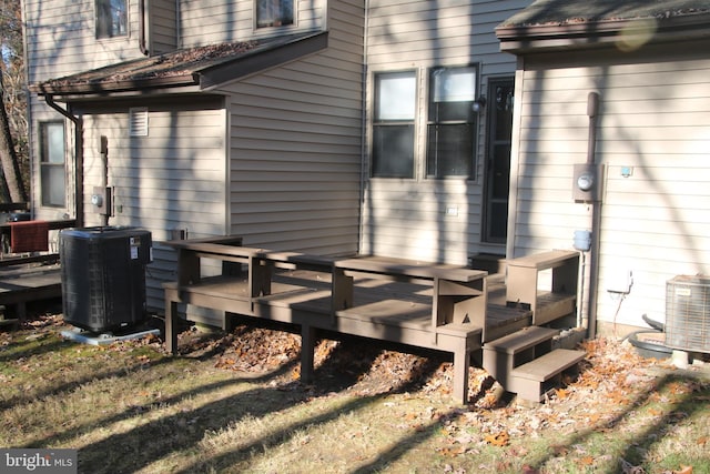 view of home's exterior featuring a deck, a yard, and central AC