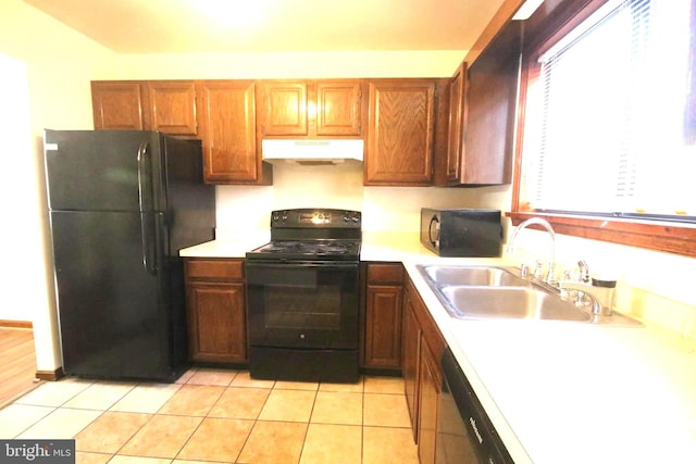 kitchen featuring sink, light tile patterned flooring, and black appliances