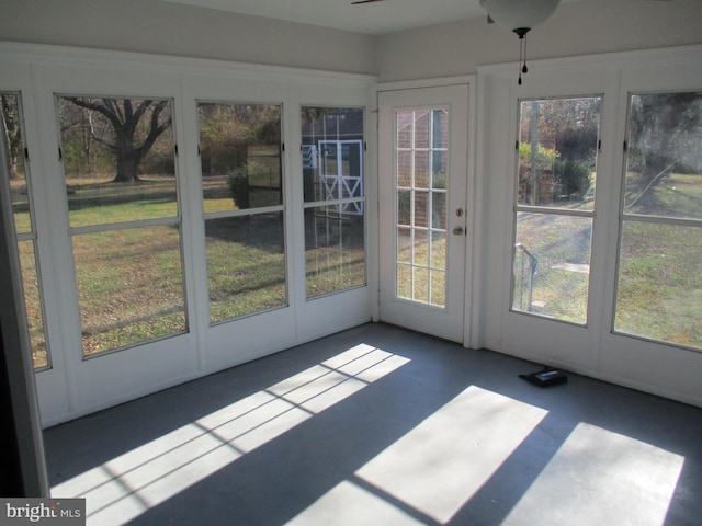 unfurnished sunroom with plenty of natural light and ceiling fan