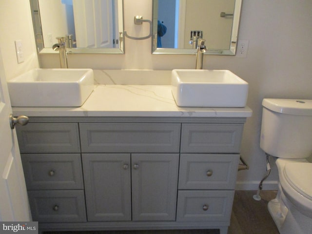 bathroom featuring wood-type flooring, vanity, and toilet