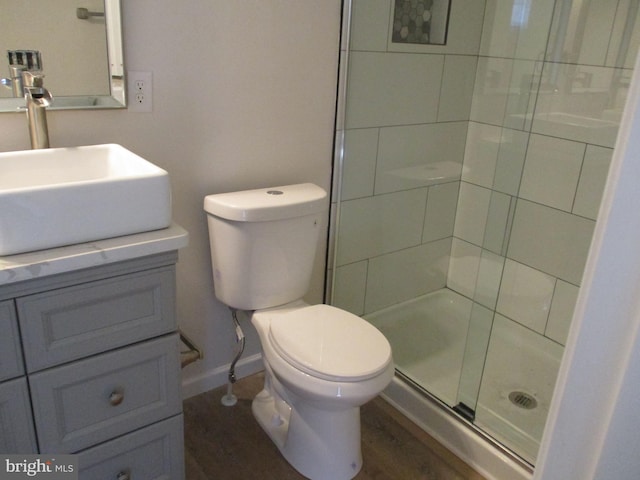 bathroom featuring hardwood / wood-style floors, vanity, an enclosed shower, and toilet