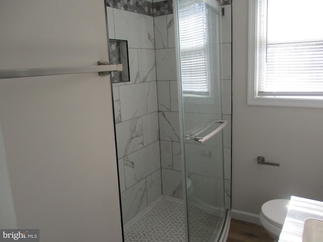 bathroom with a shower with door, wood-type flooring, and toilet