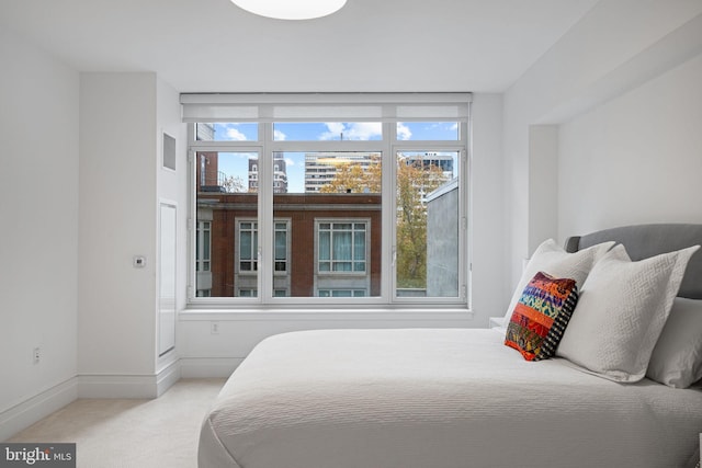 bedroom with multiple windows and light carpet