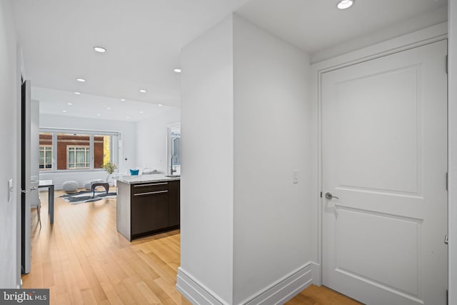 hallway featuring light hardwood / wood-style floors and sink