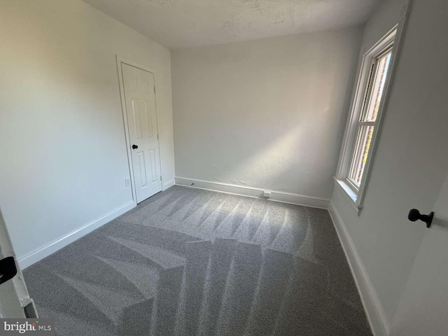 carpeted spare room featuring a textured ceiling