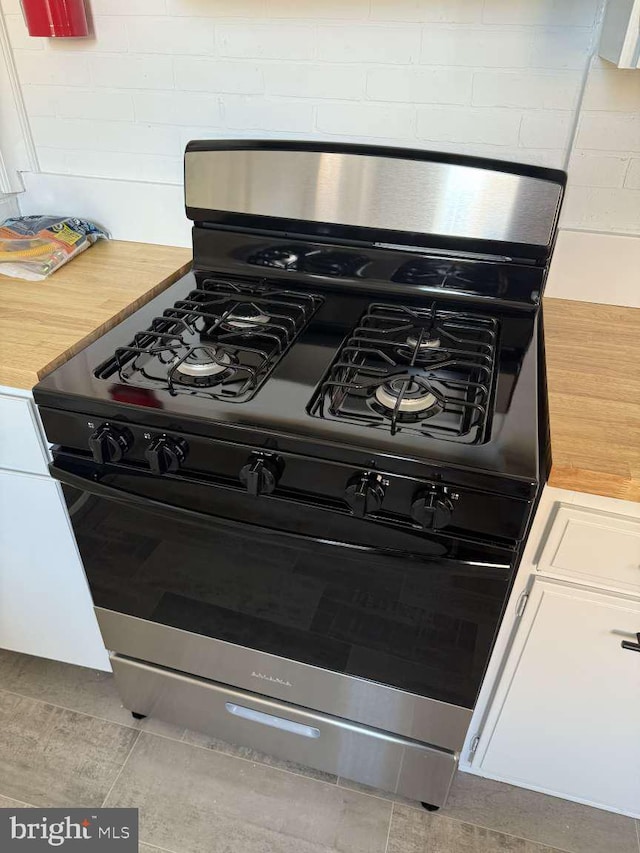 interior details featuring white cabinets and stainless steel gas stove