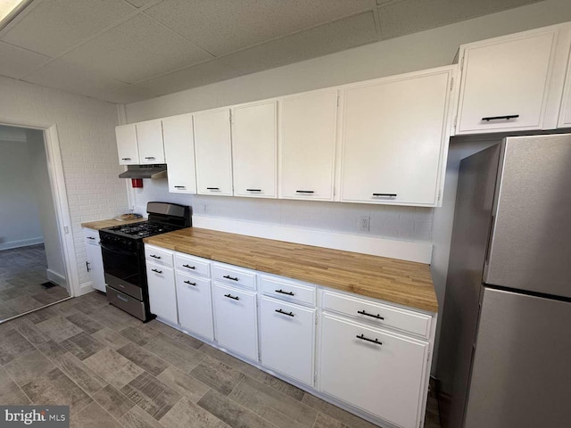 kitchen with white cabinets, stainless steel fridge, and black gas range