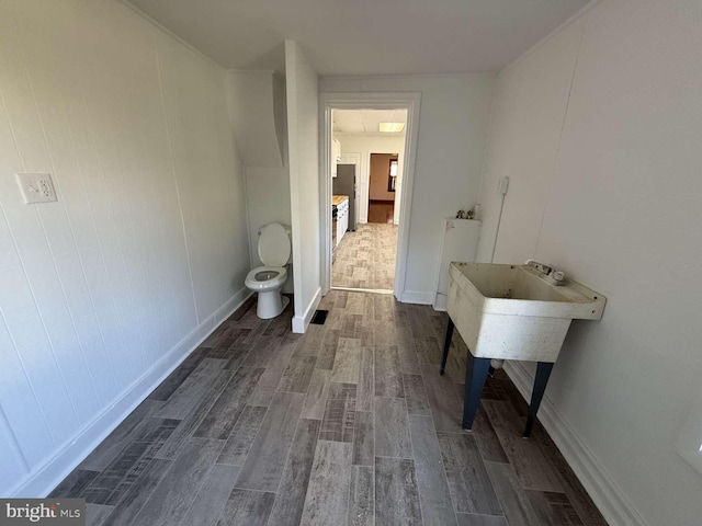 bathroom featuring toilet and wood-type flooring