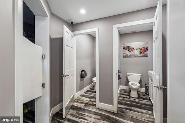 bathroom with toilet and hardwood / wood-style flooring