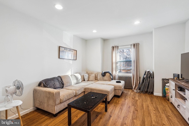 living room featuring radiator heating unit and light wood-type flooring