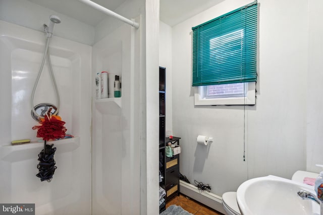 bathroom with walk in shower, sink, tile patterned flooring, and toilet