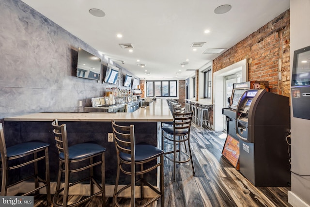 interior space featuring a kitchen bar, kitchen peninsula, and dark wood-type flooring