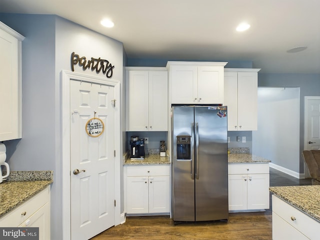 kitchen with white cabinets, stainless steel fridge with ice dispenser, dark hardwood / wood-style flooring, and light stone counters