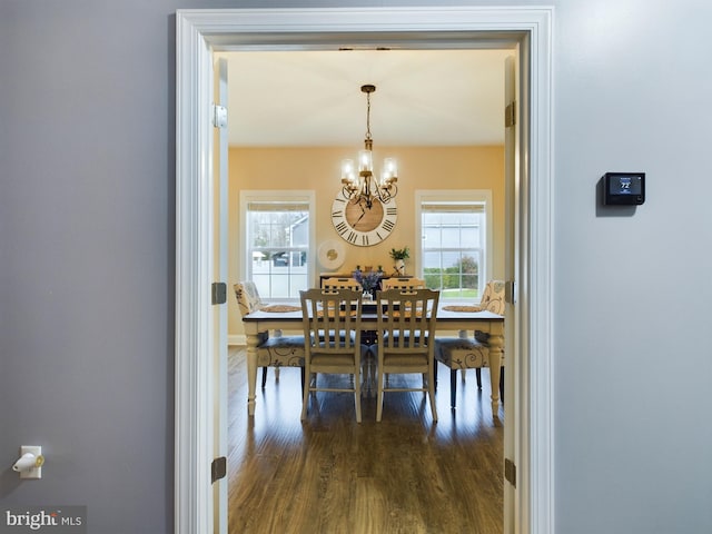 dining area featuring an inviting chandelier and dark wood-type flooring