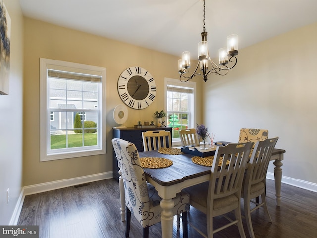 dining area with a notable chandelier and dark hardwood / wood-style flooring