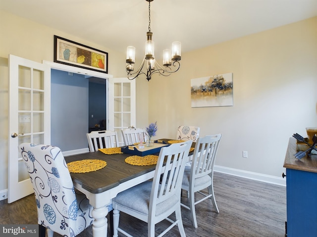 dining space with french doors, dark wood-type flooring, and a chandelier