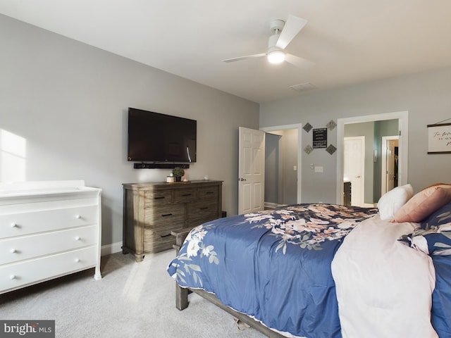 bedroom featuring ceiling fan, ensuite bathroom, and light carpet