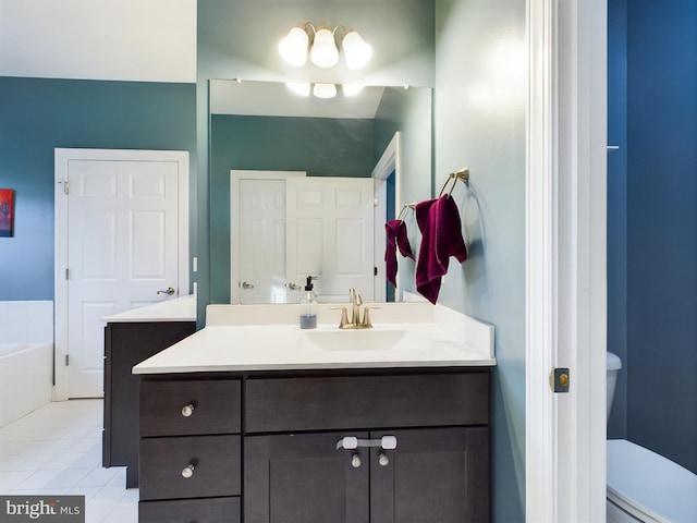 bathroom featuring tile patterned floors, vanity, toilet, and a washtub