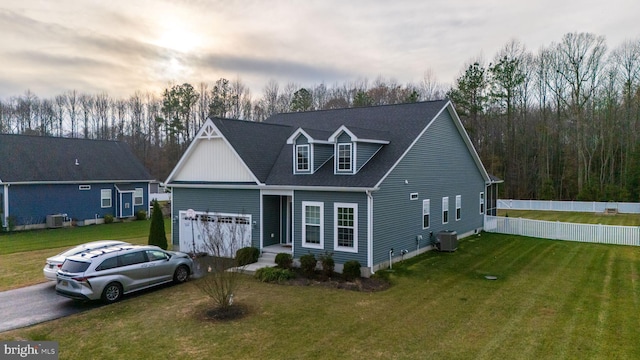 view of front of house featuring central AC unit and a lawn