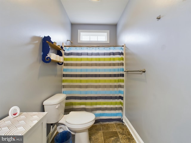 bathroom featuring a shower with curtain and toilet