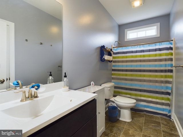 bathroom with walk in shower, vanity, and toilet