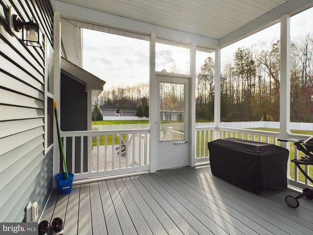 sunroom featuring a water view