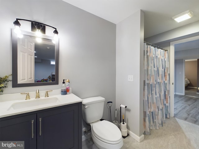 bathroom with curtained shower, vanity, and toilet