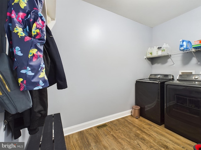 clothes washing area featuring hardwood / wood-style floors and independent washer and dryer