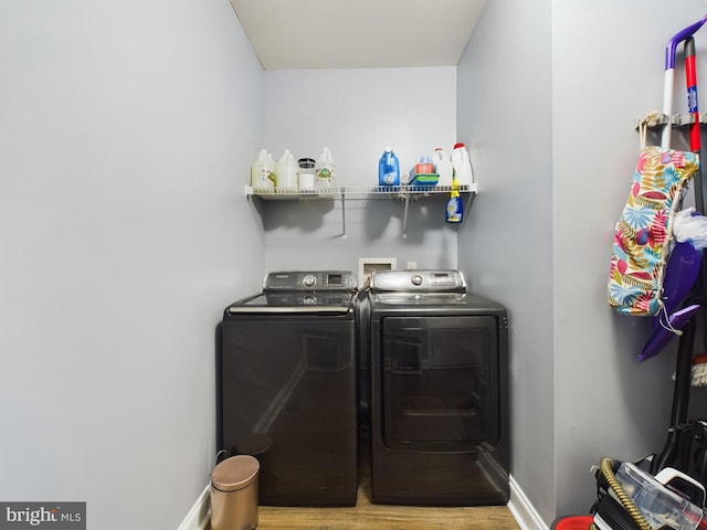 washroom with washing machine and dryer and light wood-type flooring