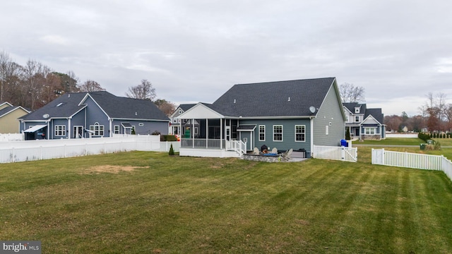 back of house with a sunroom and a yard