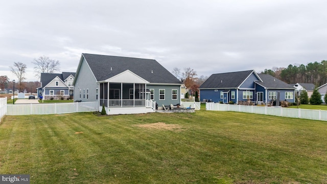 back of property featuring a lawn and a sunroom