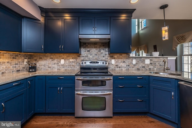 kitchen featuring blue cabinetry, decorative light fixtures, and appliances with stainless steel finishes