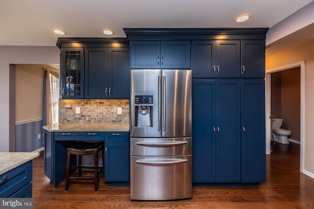 kitchen with stainless steel fridge, blue cabinetry, and dark wood-type flooring