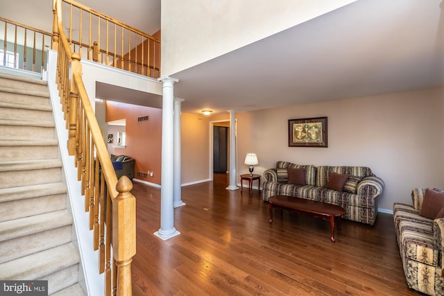 living room with decorative columns and dark hardwood / wood-style floors