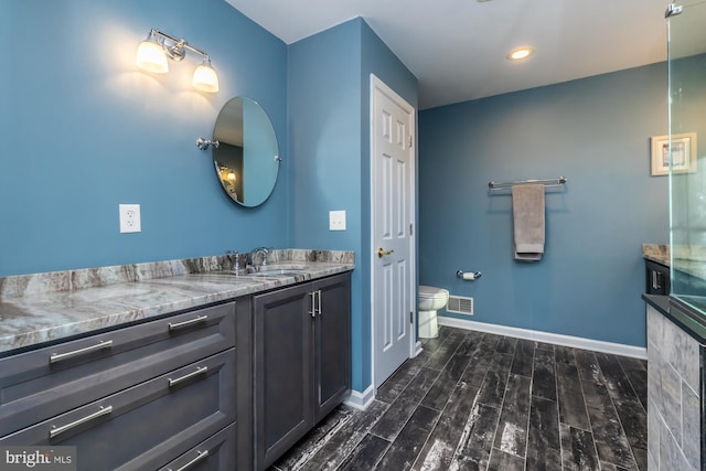 bathroom featuring vanity, hardwood / wood-style flooring, and toilet