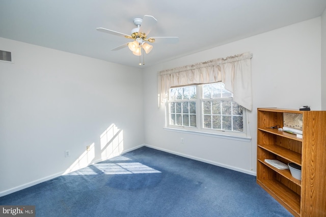 empty room with dark carpet and ceiling fan