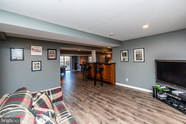 living room with bar area and dark hardwood / wood-style flooring