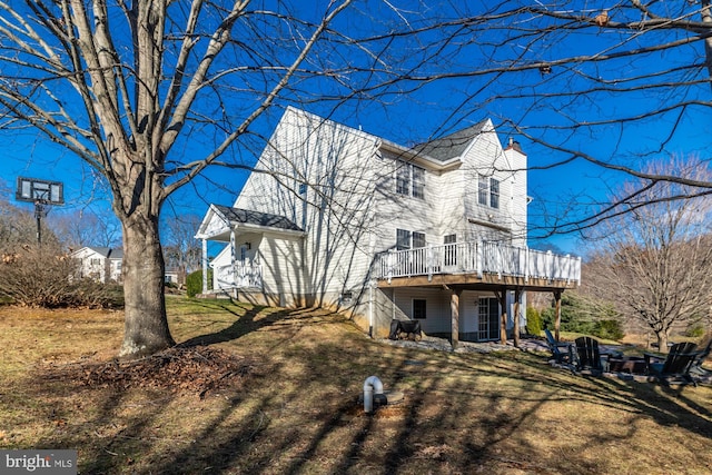 view of front of property with a wooden deck and a front yard