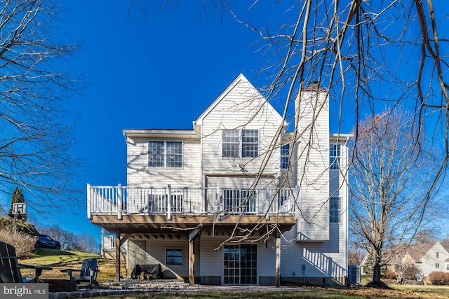 back of property with a wooden deck and central AC