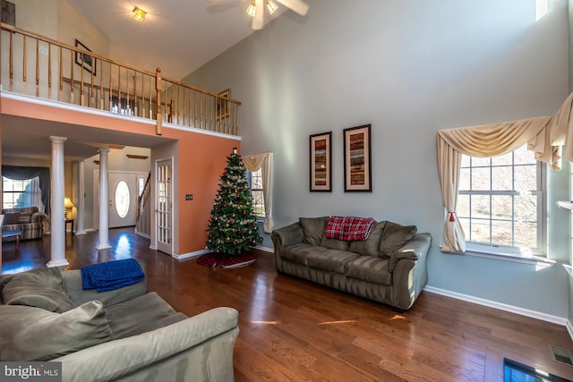 living room featuring ornate columns, ceiling fan, dark hardwood / wood-style flooring, and high vaulted ceiling