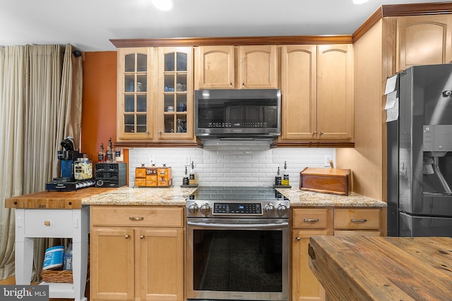 kitchen featuring stainless steel electric range, black refrigerator with ice dispenser, butcher block countertops, and decorative backsplash