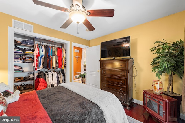 bedroom featuring ceiling fan, a closet, and dark wood-type flooring