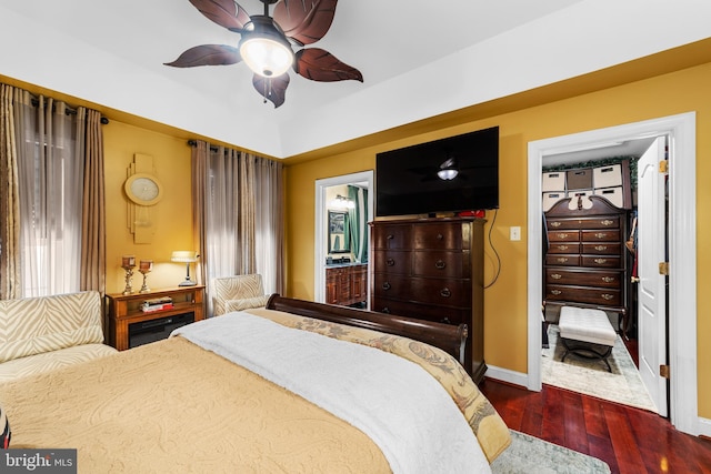 bedroom with ceiling fan, dark hardwood / wood-style flooring, and connected bathroom