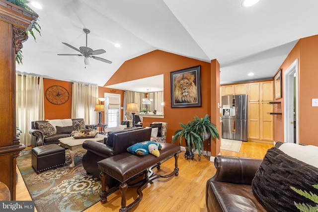 living room featuring ceiling fan, light hardwood / wood-style flooring, and lofted ceiling