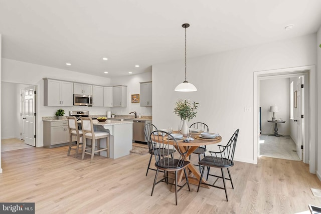 dining space with light hardwood / wood-style floors and sink